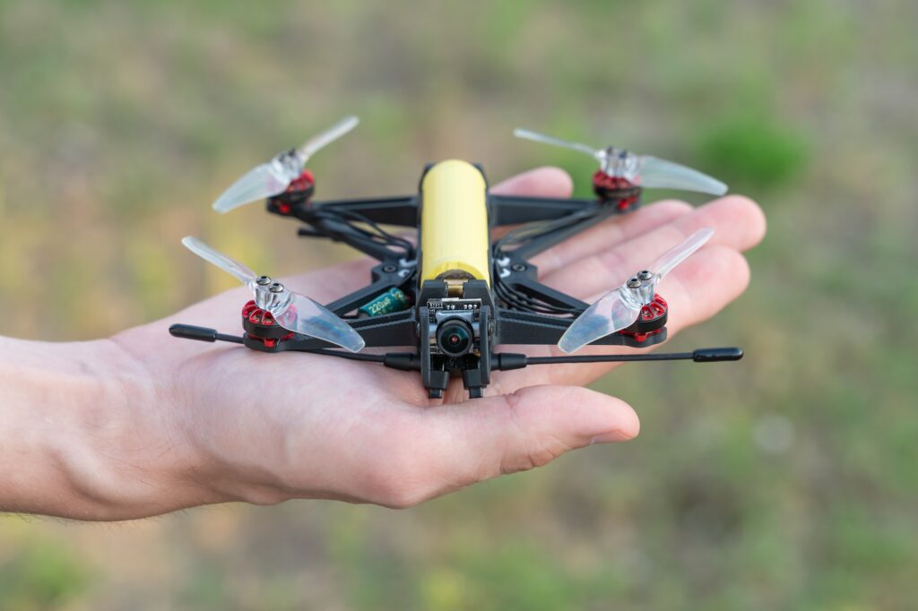 Safe quadcopter landing on the pilot's palm closeup. Man holding drone in his hand close up